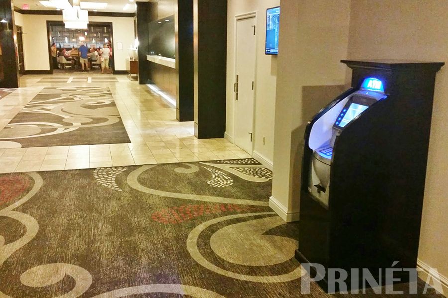 triton argo 12 atm machine with black wood cabinet in a hotel lobby